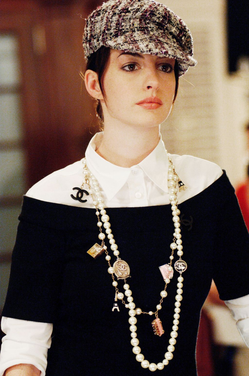 Anne Hathaway con gorra, perlas y un look Chanel en The Devil Wears Prada